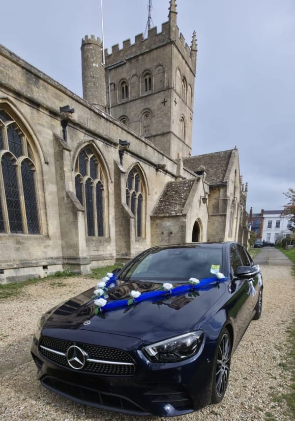 Mercedes E Class decorated for a wedding in front of a church